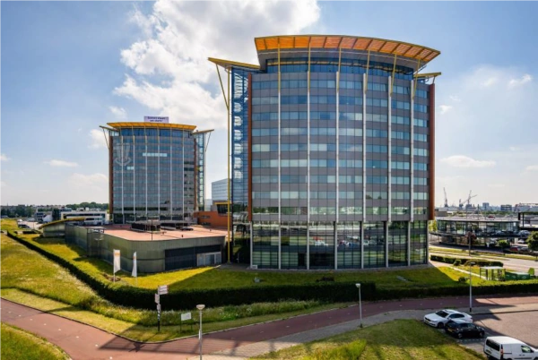 Twee moderne kantoorgebouwen aan de Karel Doormanweg met grote glasgevels en een opvallend oranje dak.